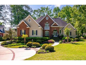 Beautiful brick and stucco home with lush landscaping and a welcoming front entrance at 8642 W Fairway Woods Dr, North Charleston, SC 29420