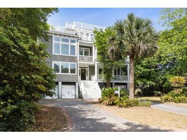Stunning multi-level home boasting a rooftop deck, complemented by a lush front yard with mature palms and trees at 9 24Th Ave, Isle of Palms, SC 29451