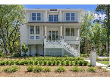 Charming two-story home featuring a welcoming porch, white railings, and beautifully landscaped front yard at 1006 Basin Ln, Johns Island, SC 29455