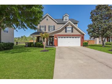 Charming two-story home with a well-manicured lawn, a two-car garage, and beautiful landscaping at 118 Netherfield Dr, Summerville, SC 29486