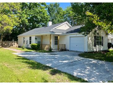 Charming single-story home with a well-maintained yard and a private driveway leading to an attached garage at 124 Droos Way, Charleston, SC 29414