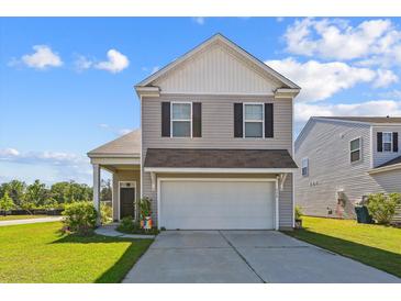 Charming two-story home featuring a two-car garage and well-manicured front lawn at 136 Pontoria Dr, Summerville, SC 29483