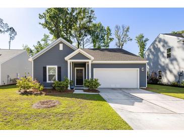 Charming single-story home featuring a two-car garage, manicured lawn, and a welcoming entrance at 1411 Thin Pine Dr, Johns Island, SC 29455