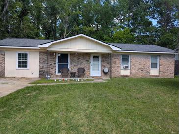 Charming single-story brick home with a well-maintained lawn and inviting front porch seating area at 225 Arbor Rd, Summerville, SC 29485