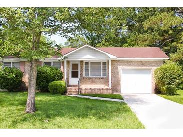 Charming brick home featuring an attached garage, mature landscaping, and a well-maintained front yard at 356 Price St, Goose Creek, SC 29445