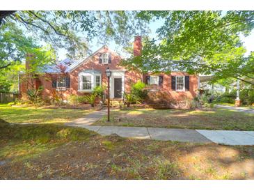 Charming brick home features a well-manicured lawn, a classic brick facade and mature trees at 41 Berkeley Rd, Charleston, SC 29407