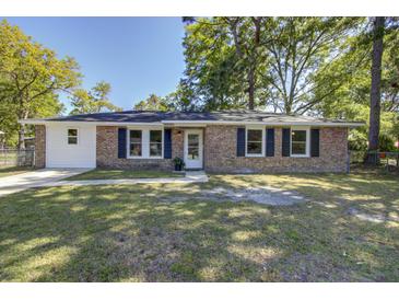 Charming brick home featuring black shutters, manicured lawn and beautiful front yard trees at 4412 Garwood Dr, Ladson, SC 29456