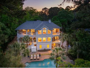 Elegant multi-story home boasting balconies, a pool, and meticulously landscaped grounds with mature trees at 4952 Steeplechase Ln, Hollywood, SC 29449