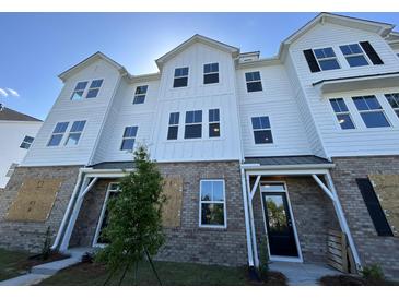 New two-story townhouse boasts white siding, brick facade, and modern architectural design at 5114 Double Eagle Loop, Summerville, SC 29485