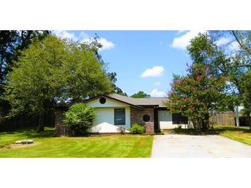 Charming single-story home with mature trees, well-manicured lawn, and a long concrete driveway at 95 Logan Dr, Summerville, SC 29483