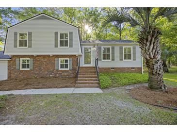 Charming home featuring brick accents, light gray siding, green shutters, and a well manicured yard at 104 Huntington Cir, Summerville, SC 29485