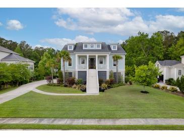Charming light-blue two-story home with a welcoming staircase, columns, a well-manicured lawn, and lush landscaping at 1104 Beresford Run, Charleston, SC 29492