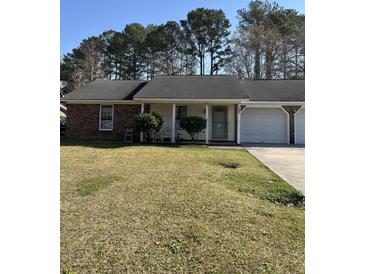 Single-story home with two car garage, set on a level lot at 142 Aylesbury Rd, Goose Creek, SC 29445