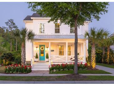 Charming two-story white home featuring a welcoming front porch, manicured landscaping, and a bright turquoise front door at 1526 Old Rivers Gate Rd, Mount Pleasant, SC 29466