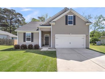 Charming single-Gathering home showcasing a well-manicured lawn and two-car garage at 171 Sara St, Saint George, SC 29477