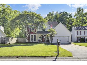 Charming two-story home with well-manicured lawn, mature trees, and attached garage at 2021 Beckton St, North Charleston, SC 29420