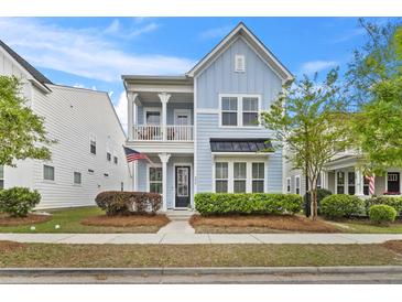 Charming two-story home featuring a balcony, light blue siding, manicured landscaping, and inviting curb appeal at 245 Ribbon Rd, Summerville, SC 29483