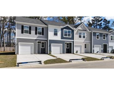 New townhomes showcase varied siding colors, complemented by attached garages and well-maintained lawns at 2603 Scarlett Maple St, Summerville, SC 29486