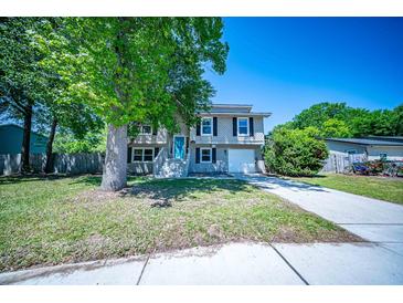 Charming home featuring a blue door, black shutters, and a spacious front yard with mature trees at 2920 Newport Pl, North Charleston, SC 29420