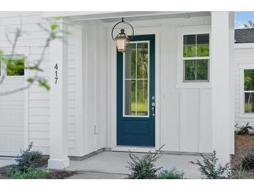 Charming home entrance with a teal front door, classic lantern, and white siding at 354 Claret Cup Way, Charleston, SC 29414