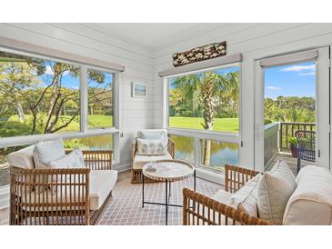 Bright sunroom boasts tranquil views, shiplap walls, and coastal decor, creating a serene and inviting space at 4947 Green Dolphin Way, Kiawah Island, SC 29455