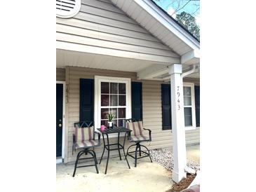 Inviting front porch featuring two swivel chairs and a small table with a plant at 7943 Vermont Rd, North Charleston, SC 29418