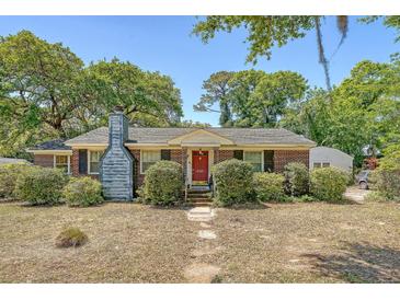 Charming brick home with a well-manicured front yard, mature trees, and a welcoming red front door at 1012 Cliffwood Dr, Mount Pleasant, SC 29464