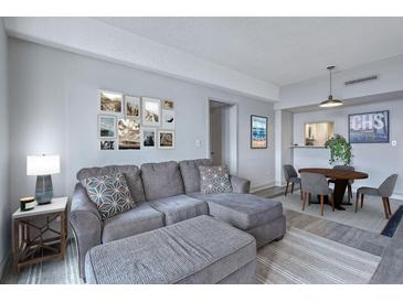 Bright living room features a comfortable gray couch, stylish decor, and an inviting dining area at 14 Lockwood Dr # 11H, Charleston, SC 29401