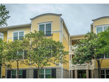 Lovely yellow condominium building with well-maintained landscaping, featuring mature trees at 1832 Telfair Way # 1832, Charleston, SC 29412