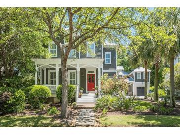 Charming two-story home with a inviting front porch, beautiful landscaping, and a bright red front door at 22 Frogmore Rd, Mount Pleasant, SC 29464