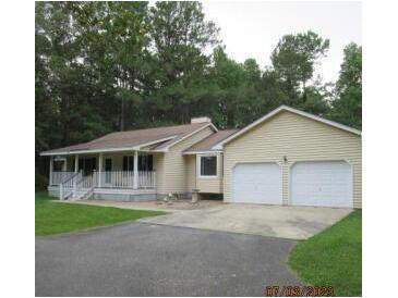 Inviting ranch-style home with a charming front porch and a two-car garage on a large lot at 302 Summerset Ln, Summerville, SC 29483