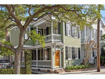 Charming two-story home with a porch, balcony, light green siding, and black shutters at 34 Pinckney St, Charleston, SC 29401