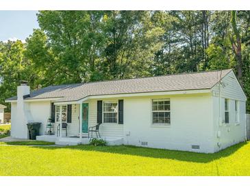 Charming one-story home featuring a white brick exterior, manicured lawn, and a quaint front porch at 407 Tammie Ave, Goose Creek, SC 29445