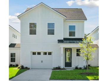 Charming two-story home with white siding, a garage, and a well-manicured lawn, creating a welcoming curb appeal at 487 Queenview Ln, Charleston, SC 29414