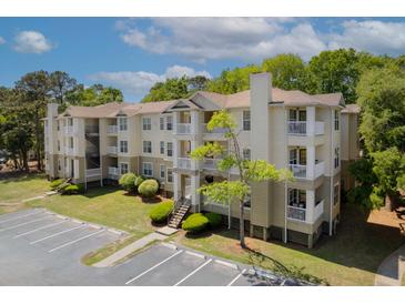 Inviting multi-story apartment building features balconies, lush landscaping, and convenient parking at 700 Daniel Ellis Dr # 10307, Charleston, SC 29412