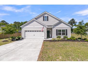 Charming single-Gathering home with manicured lawn and attached two-car garage at 707 Butter Rd, Bonneau, SC 29431
