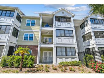 Attractive condo building showcasing balconies, neutral colors, decorative trim and lush, manicured landscaping at 1025 Riverland Woods Pl # 1008, Charleston, SC 29412