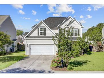 Charming two-story home with a well-manicured lawn, attached garage and beautiful landscaping at 104 Valentin Dr, Summerville, SC 29483