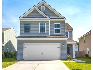 Charming two-story home features a two-car garage and neutral gray siding at 124 Sumac Dr, Goose Creek, SC 29445