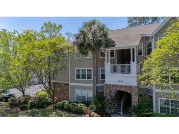 Charming condo exterior with a lovely brick archway and lush green landscaping and trees at 188 Midlands Pkwy # 507, Summerville, SC 29485