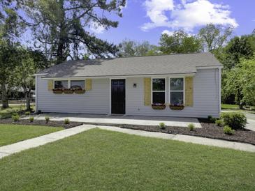 Charming one-story home featuring a well-manicured lawn and flower boxes under the windows at 3105 Matipan Ave, North Charleston, SC 29405