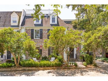 Charming brick home with dormer windows, mature trees, and an inviting entrance at 39 N Adgers Wharf, Charleston, SC 29401