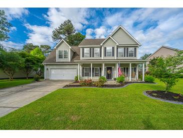 Charming two-story home with a well-manicured lawn and inviting front porch at 411 Black Horse Rd, Moncks Corner, SC 29461