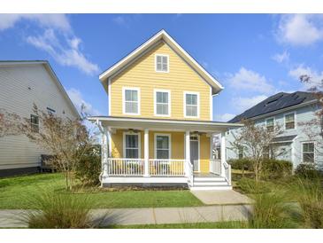 Charming two-story yellow home with a welcoming front porch and well-maintained lawn on a sunny day at 4906 W Liberty Park Cir, North Charleston, SC 29405