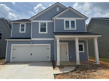 Charming two-story home with blue siding, white trim, and a spacious two-car garage at 575 Red Monarch Way, Moncks Corner, SC 29461