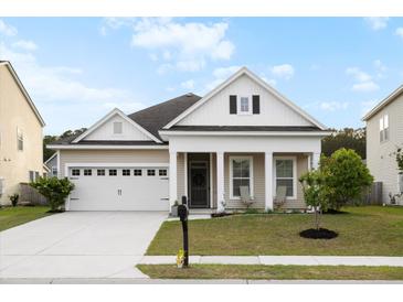 Charming single-story home with a well-manicured lawn and covered porch at 589 Crossland Dr, Moncks Corner, SC 29461