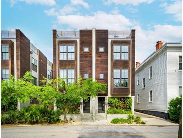 Stunning modern townhome with a wood facade, private rooftop terrace, and professionally landscaped entryway at 62 Gadsden St # A, Charleston, SC 29401