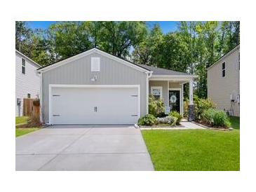 Charming single-story home with a two-car garage, landscaped yard, and a welcoming front entrance at 655 Jancus St, Charleston, SC 29414