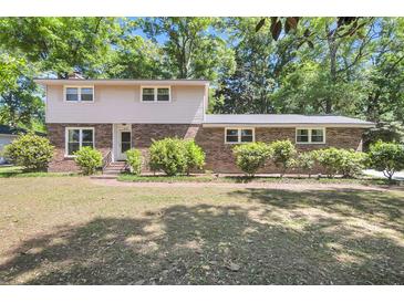 Charming two-story home with a brick facade, lush landscaping, and a well-maintained lawn at 679 Edmonds Dr, Charleston, SC 29412