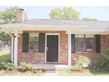 Charming brick home with a cozy front porch, black shutters, and manicured landscaping at 7712 Corley Dr, North Charleston, SC 29418